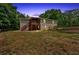 Expansive backyard featuring a charming deck, complemented by a wooden fence and lush surrounding trees at dusk at 428 Hulseytown Rd, Dallas, GA 30157