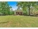 Scenic view of a charming home with a spacious yard, framed by lush greenery and mature trees at 428 Hulseytown Rd, Dallas, GA 30157