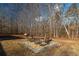 Well-kept backyard with a gravel area and fire pit surrounded by woodlands at 4286 Pool Rd, Winston, GA 30187