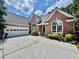 Charming red brick home with a two car garage, arched windows, and a concrete driveway at 1902 Commons View Cir, Snellville, GA 30078