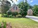 Charming brick home with a lush green lawn and mature trees at 1902 Commons View Cir, Snellville, GA 30078