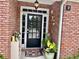 Welcoming front door with brick facade, plants, and decorations creating a cozy entrance at 1902 Commons View Cir, Snellville, GA 30078