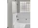 Close up of tub with white tile surround and block glass window at 4092 Arabian Way, Snellville, GA 30039