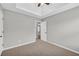 Bedroom featuring neutral walls, plush carpet, and a tray ceiling with a ceiling fan at 4092 Arabian Way, Snellville, GA 30039