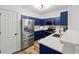 Modern kitchen features stainless steel appliances, sleek blue cabinets, and a breakfast bar at 132 Timber Mist Ln, Lawrenceville, GA 30045