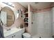 Bathroom with a shower, vanity, storage shelves, and neutral color scheme at 511 Reid St, Villa Rica, GA 30180