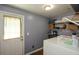 A simple laundry area with a door to the exterior, washer, dryer, and wire shelving at 511 Reid St, Villa Rica, GA 30180