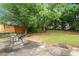A picturesque backyard features a stone patio, a fire pit, and lush greenery at 530 Georgian Hills Dr, Lawrenceville, GA 30045