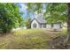 Secluded backyard surrounded by mature trees, featuring a well-manicured lawn, and a white picket fence at 530 Georgian Hills Dr, Lawrenceville, GA 30045
