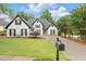 Charming white home with manicured lawn, black shutters, and a long driveway at 530 Georgian Hills Dr, Lawrenceville, GA 30045