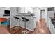 A kitchen with bar seating and stainless appliances overlooks an adjacent living room at 530 Georgian Hills Dr, Lawrenceville, GA 30045
