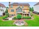Beautiful backyard with a fire pit, large deck, manicured lawn, mature trees, and attractive exterior at 1346 Wind Chime Ct, Lawrenceville, GA 30045