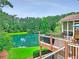 Stunning backyard with deck overlooking lake, grill, seating area and serene, natural surroundings at 1346 Wind Chime Ct, Lawrenceville, GA 30045
