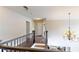 Hallway with hardwood flooring, stairs, and decorative hanging chandelier at 1346 Wind Chime Ct, Lawrenceville, GA 30045