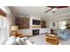 Cozy living room with custom built-ins, a fireplace, hardwood floors, and a ceiling fan at 1346 Wind Chime Ct, Lawrenceville, GA 30045