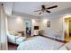 Bright main bedroom featuring a ceiling fan, sitting area, desk, and connecting bathroom at 1346 Wind Chime Ct, Lawrenceville, GA 30045