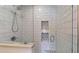 Shower featuring white subway tile, a glass door, built-in shelving, and decorative tile accents at 1346 Wind Chime Ct, Lawrenceville, GA 30045