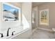 Soaking tub area features a large window, white subway tile, and black fixtures at 2080 Cactus Ln, Cumming, GA 30040
