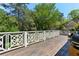 Spacious wooden deck with decorative white railings offers a serene outdoor living area surrounded by lush greenery at 3005 Howell Mill Rd, Atlanta, GA 30327