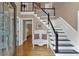 Bright foyer with hardwood floors, a staircase, decorative bench, and large glass paneled front door at 5804 Fairwood Nw Cir, Acworth, GA 30101