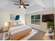 Staged main bedroom features a tray ceiling, a ceiling fan, and a large window at 1792 Portwest Way, Hampton, GA 30228