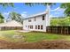 Green backyard lawn with perimeter plants and a white sided house at 1980 Heatherton Rd, Dacula, GA 30019