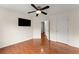 Spacious bedroom featuring hardwood floors, ceiling fan, and a mounted television at 1980 Heatherton Rd, Dacula, GA 30019