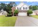 Charming two-story home featuring a brick and white exterior, landscaped yard, and an extended driveway at 1980 Heatherton Rd, Dacula, GA 30019