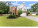 Charming two-story home with brick facade, manicured lawn, trimmed bushes, and a two-car garage at 1980 Heatherton Rd, Dacula, GA 30019