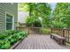 Wooden back deck with bench seating and lush landscaping in a private backyard setting at 11260 Havenwood Dr, Johns Creek, GA 30097