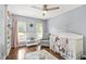A beautiful Bedroom with a crib, bookshelves, a ceiling fan, and a serene view of the outdoors at 11260 Havenwood Dr, Johns Creek, GA 30097