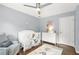 Charming Bedroom features a white crib, a comfortable grey armchair and hardwood floors at 11260 Havenwood Dr, Johns Creek, GA 30097