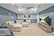 Spacious living room featuring a large sectional sofa, wall-mounted TV, and modern ceiling fan at 11260 Havenwood Dr, Johns Creek, GA 30097