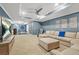 Spacious living room featuring a large sectional sofa, wall-mounted TV, and modern ceiling fan at 11260 Havenwood Dr, Johns Creek, GA 30097