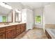 This main bathroom features tile floors, double sink vanity with wood cabinets, and a bright window at 11260 Havenwood Dr, Johns Creek, GA 30097