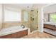 A relaxing ensuite bathroom with tile floors, a shower, and a tub situated beneath a bright window at 11260 Havenwood Dr, Johns Creek, GA 30097