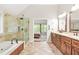 Bright main bathroom featuring a glass shower, soaking tub, and and sink with wood cabinets at 11260 Havenwood Dr, Johns Creek, GA 30097