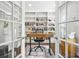 Office space with glass doors, hardwood floors, and built-in bookshelves filled with an assortment of books at 11260 Havenwood Dr, Johns Creek, GA 30097