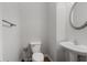 Clean half bathroom with modern fixtures, a sleek round mirror, and a pedestal sink at 1529 Liberty Nw Pkwy, Atlanta, GA 30318