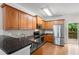 Well-lit kitchen featuring wood cabinets, stainless steel appliances, granite countertops, and access to the outdoor deck at 1529 Liberty Nw Pkwy, Atlanta, GA 30318