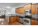 Open-concept kitchen showcasing wood cabinets, stainless steel appliances, granite countertops, and hardwood floors at 1529 Liberty Nw Pkwy, Atlanta, GA 30318