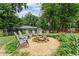 Cozy fire pit area with seating, surrounded by lush greenery and providing an inviting outdoor space at 2904 Masonwood Nw Dr, Kennesaw, GA 30152