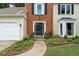 Inviting front entrance featuring a beautifully landscaped walkway, decorative plants, and brick accents at 2904 Masonwood Nw Dr, Kennesaw, GA 30152