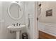 Cozy powder room features a pedestal sink, round mirror, and a decorative sign at 2904 Masonwood Nw Dr, Kennesaw, GA 30152