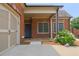 A welcoming brick front entrance features a covered porch, blooming hydrangeas, and convenient garage access at 4347 Lanier Ridge Walk # 1501, Cumming, GA 30041