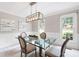 Well-lit dining room with a glass table, elegant chairs, and a view of the outdoors through large windows at 4497 Windsor Oaks Dr, Marietta, GA 30066