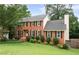 Traditional brick home with black shutters, a well-kept lawn, and mature landscaping enhancing curb appeal at 4497 Windsor Oaks Dr, Marietta, GA 30066