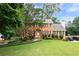 Beautiful two-story brick home featuring a lush front yard, classic shutters, and a welcoming entrance at 4497 Windsor Oaks Dr, Marietta, GA 30066