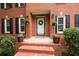 Detailed view of the brick steps leading to the front door, flanked by potted plants and charming accents at 4497 Windsor Oaks Dr, Marietta, GA 30066