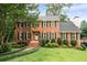 Charming brick home with a lush green lawn, mature trees, and classic architectural details at 4497 Windsor Oaks Dr, Marietta, GA 30066